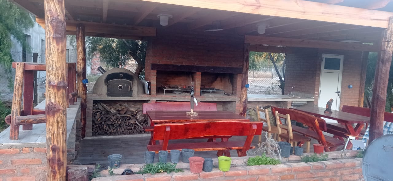 Quincho techado con horno de barro y asadores
